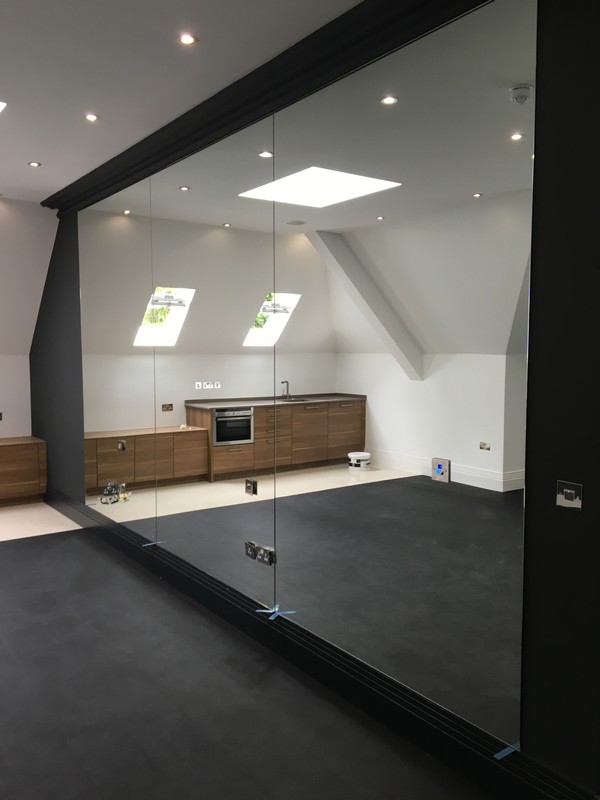 Frameless glass partition in loft conversion by Thamesmead glaziers